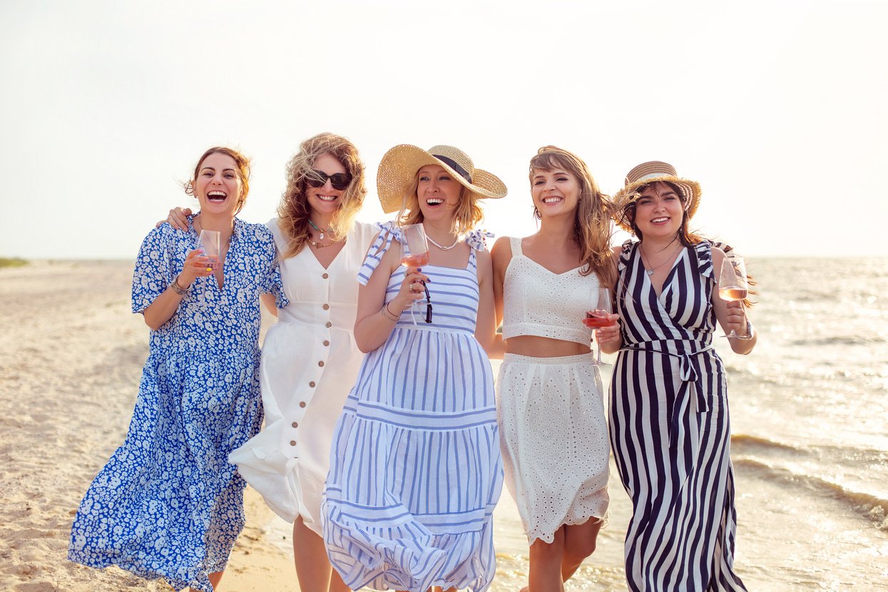 Cheerful Women with Wine Walking on Beach